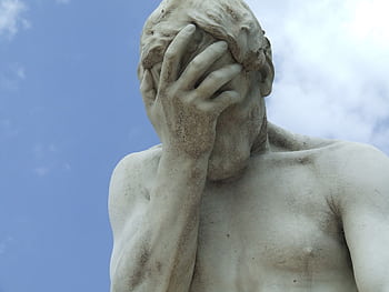 A dramatic close-up of a renowned statue in Paris expressing frustration. HD wallpaper