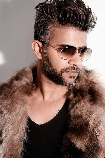 Fashion-forward man wearing a fur coat and sunglasses, exuding style. HD phone wallpaper