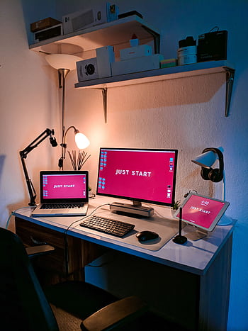 A stylish home office setup featuring a laptop, monitor, and tech accessories on a desk with cozy lighting. HD phone wallpaper