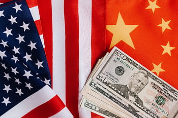 Close-up of US and China flags with US dollar bills, representing international trade and finance. HD wallpaper