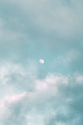 Tranquil clouds surrounding the moon on a clear day, embodying peace and calm. HD phone wallpaper