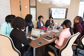 Diverse team engaging in a productive business meeting in a modern office setting. HD wallpaper