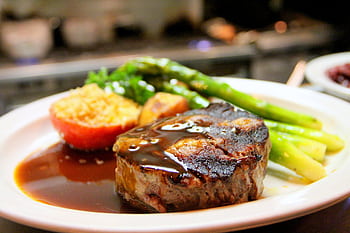 Delicious grilled steak with asparagus and tomato served with rich sauce on a plate. HD wallpaper