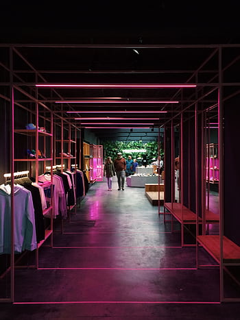 Interior of a modern clothing store in Antwerp, featuring neon pink lights and a sleek design. HD phone wallpaper