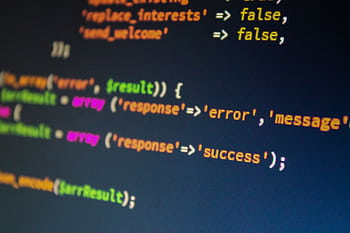 Close-up of PHP code on a monitor, highlighting development and programming concepts. HD wallpaper