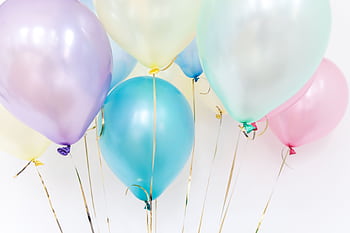 Pastel balloons floating against a neutral background, perfect for festive events. HD wallpaper