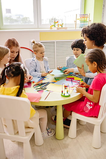 Children engaged in creative activities during an art class at a preschool, fostering learning and fun. HD phone wallpaper