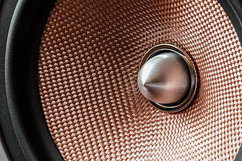 Detailed view of a metallic speaker cone with textured pattern and modern design. HD wallpaper