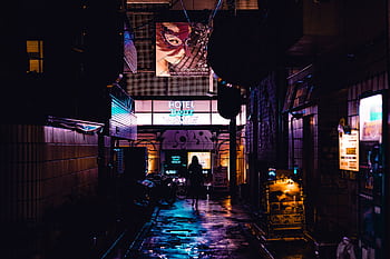 Silhouette of a person walking in a vibrant, neon-lit alleyway in Shinjuku, Tokyo at night. HD wallpaper
