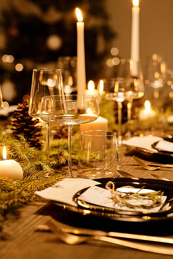 Warm and elegant Christmas dinner table decorated with candles and greenery, perfect for the holiday season. HD phone wallpaper