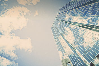 A stunning skyscraper in London, Ontario reflecting clouds on its glass facade. HD wallpaper