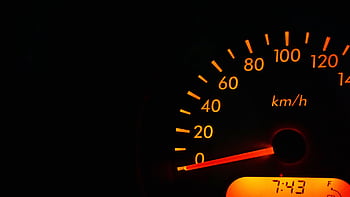 Night view of a car speedometer illuminated in orange, showing kilometers per hour. HD wallpaper