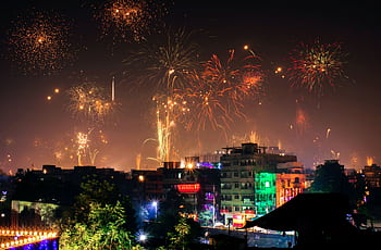 Vibrant fireworks light up the night sky during a festival in an Indian city. HD wallpaper