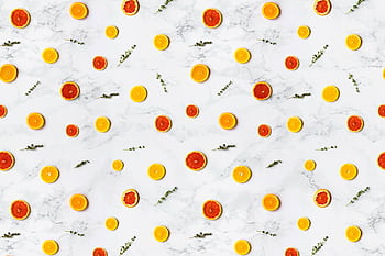 Colorful citrus slices arranged in a flat lay pattern on a marble surface, ideal for backgrounds. HD wallpaper