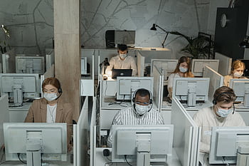 Multicultural team wearing masks in a call center managing customer support during the day. HD wallpaper