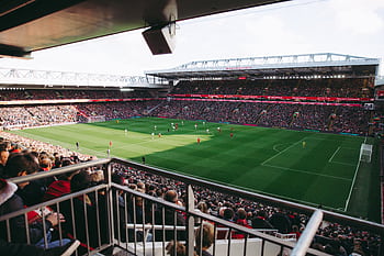 A vibrant soccer game with a full crowd in a modern stadium, capturing the energy of the sport. HD wallpaper