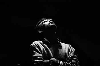 Dramatic black and white portrait of a man looking upwards in low light. HD wallpaper