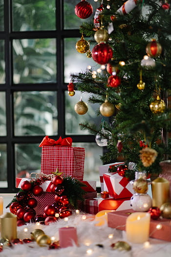 A beautifully decorated Christmas tree with colorful gifts and ornaments indoors, exuding a festive atmosphere. HD phone wallpaper