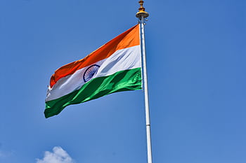 The Indian national flag waving against a clear blue sky symbolizes patriotism and national pride. HD wallpaper