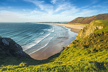 Scenic view of coastal cliffs and ocean waves under a clear sky, perfect for nature and travel themes. HD wallpaper