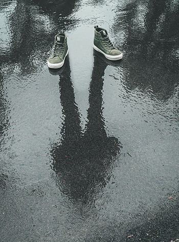 Creative of sneakers with a human reflection on wet pavement, capturing mystery and creativity. HD phone wallpaper