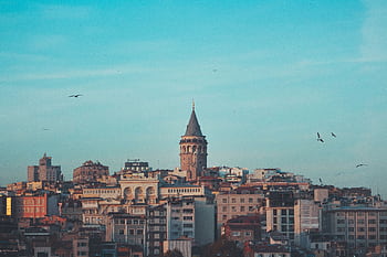 Beautiful cityscape featuring the iconic Galata Tower under a blue sky in Istanbul. HD wallpaper