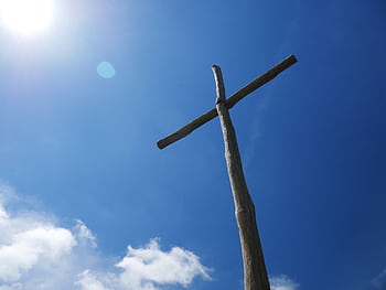 Low angle view of a wooden cross under a clear blue sky with bright sunlight. HD wallpaper