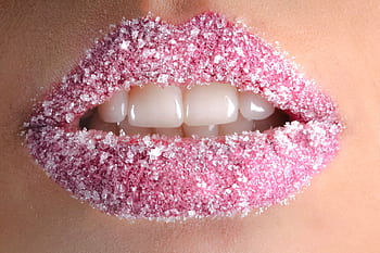Artistic close-up of lips coated with pink sugar crystals, showcasing beauty and creativity. HD wallpaper