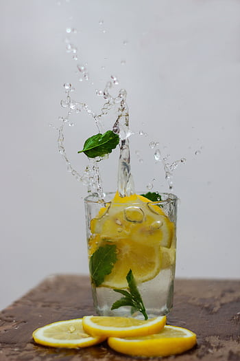 Dynamic shot of lemon and mint slices splashing in water, a refreshing still life. HD phone wallpaper