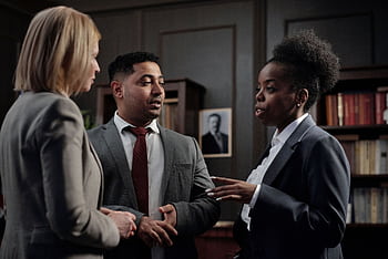Diverse professionals engaged in strategic discussion in a law office setting. HD wallpaper