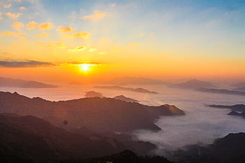 Stunning sunrise scene with mist-covered valleys and majestic mountain landscape. HD wallpaper