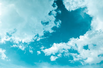 A vibrant scene of cumulus clouds floating in a bright blue sky, creating a serene and dreamy atmosphere. HD wallpaper
