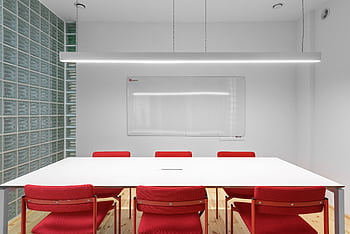 A contemporary meeting room with bright red chairs and a white table, featuring a sleek minimalist design. HD wallpaper