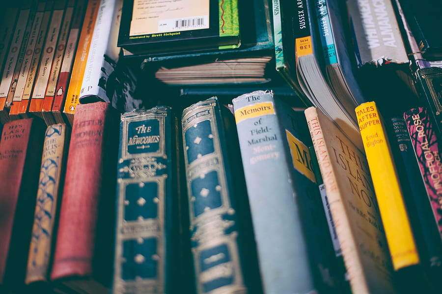 Explore a collection of vintage books with colorful spines on a wooden shelf. Perfect for literature lovers. HD wallpaper