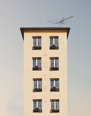A minimalist hotel facade showcasing clean lines, symmetry, and bright daylight. HD phone wallpaper