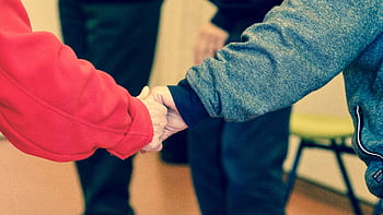 Close-up of elderly hands holding, symbolizing friendship and support indoors. HD wallpaper