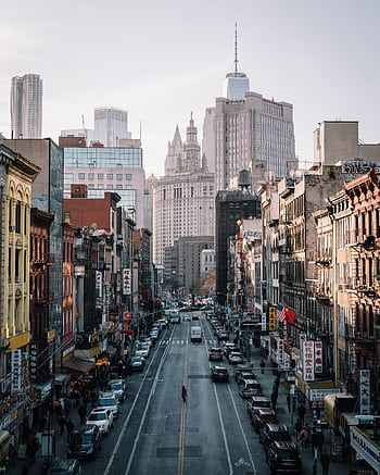 A bustling city street in New York City with people and cars under skyscrapers. HD phone wallpaper