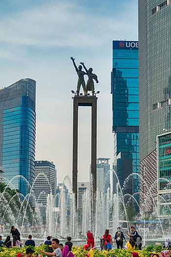 Famous statue surrounded by skyscrapers and fountain in Jakarta, Indonesia. HD phone wallpaper