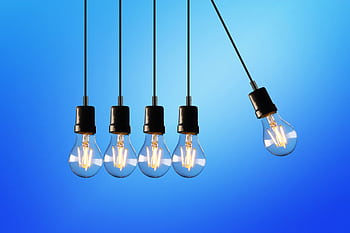 Hanging Edison-style light bulbs against a vibrant blue backdrop, showcasing energy and innovation. HD wallpaper