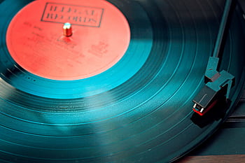 A detailed close-up view of a vintage vinyl record spinning on a turntable, capturing its nostalgic beauty. HD wallpaper