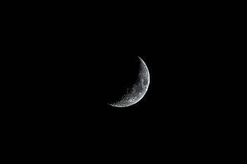 A detailed crescent moon illuminates a dark night sky, captured over Morocco. HD wallpaper