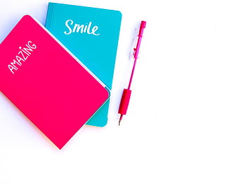 Colorful flat lay with turquoise and pink notebooks and matching pen on white background. HD wallpaper