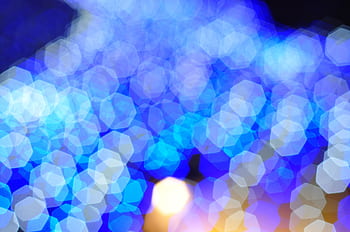 Colorful abstract bokeh background featuring vibrant blue light patterns and hexagonal shapes. HD wallpaper