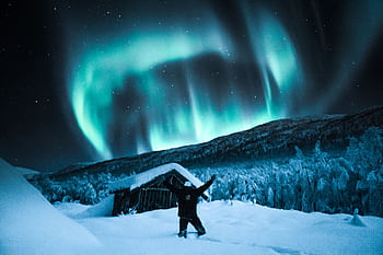 Vibrant northern lights illuminate a winter night sky in snowy Norway. Perfect for travel and nature enthusiasts. HD wallpaper