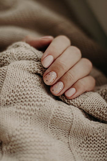 Close-up of a hand with polka dot manicured nails wrapped in a knitted sweater. HD phone wallpaper