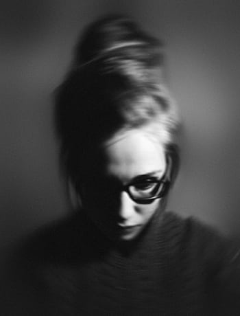 Grayscale portrait of a woman with glasses, exhibiting a pensive mood in studio lighting. HD phone wallpaper