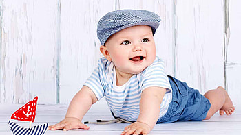 Smiling Cute Boy Baby Is Lying Down On Floor Wearing White Blue Dress And Cap Girls HD wallpaper