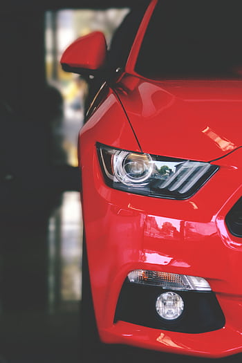 Detailed view of a sleek red sportscar showcasing elegant design and modern headlights. HD phone wallpaper