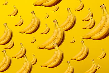 A creative and vibrant pattern of bananas against a bright yellow background, ideal for lively designs. HD wallpaper
