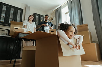 Family enjoys a joyful moment while unpacking boxes in their new kitchen. HD wallpaper